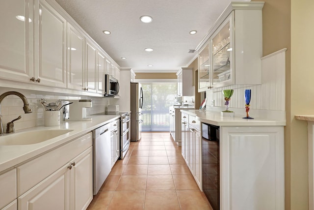 kitchen featuring sink, appliances with stainless steel finishes, tasteful backsplash, and white cabinetry