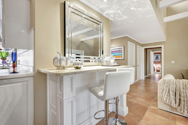 bar featuring light tile floors and white cabinetry