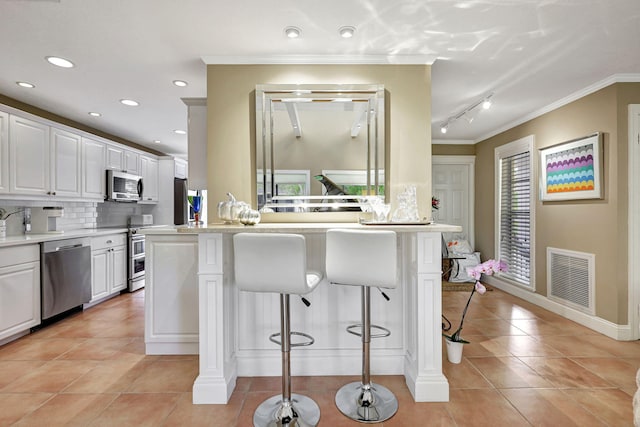 kitchen with a wealth of natural light, stainless steel appliances, and white cabinetry