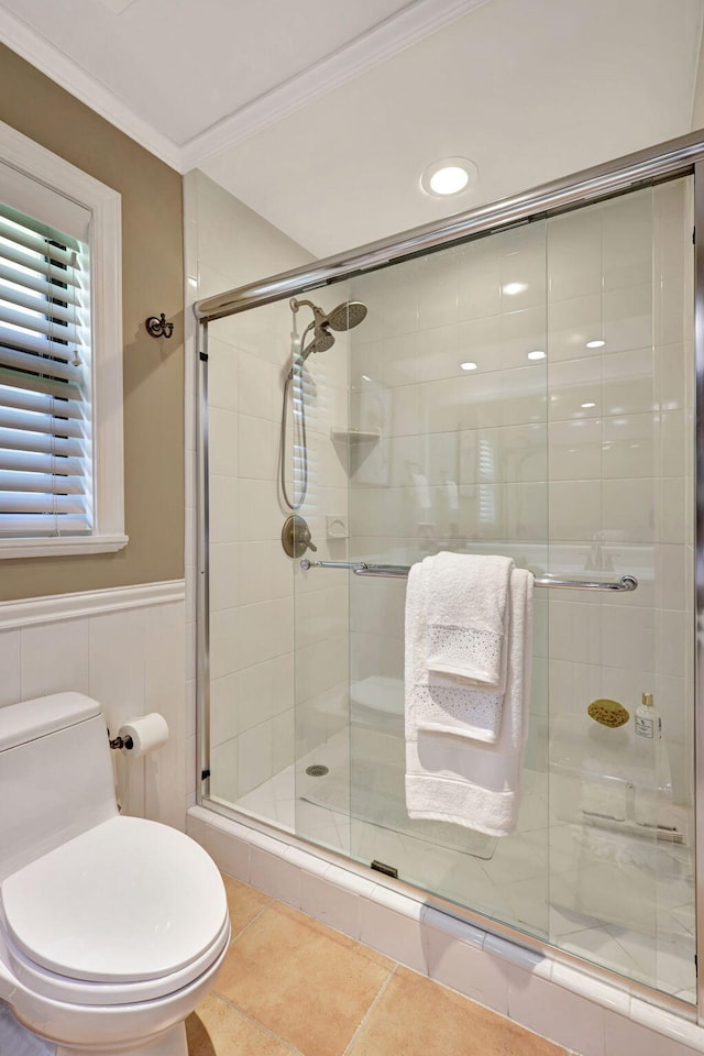 bathroom with tile flooring, an enclosed shower, toilet, and ornamental molding