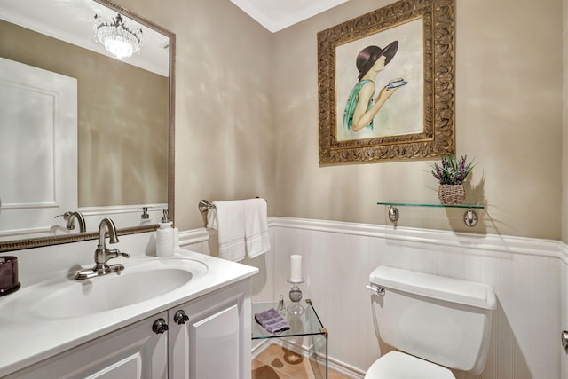 bathroom with ornamental molding, vanity, and toilet