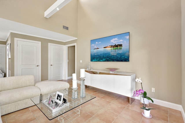 living room with a towering ceiling and light tile flooring