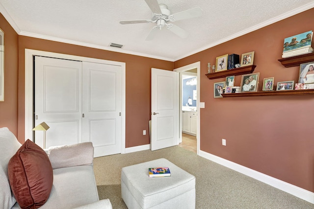 living area featuring light colored carpet, a textured ceiling, ceiling fan, and crown molding