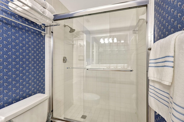 bathroom with a shower with door and toilet