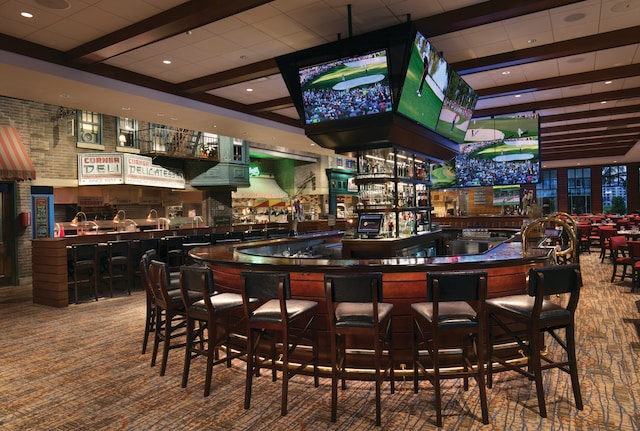 bar featuring carpet flooring and beamed ceiling