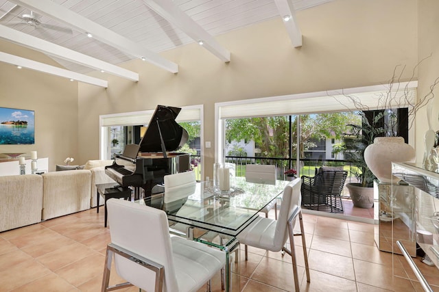 dining room with beamed ceiling, high vaulted ceiling, and light tile floors