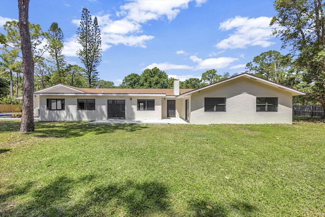 single story home with a front yard and a patio