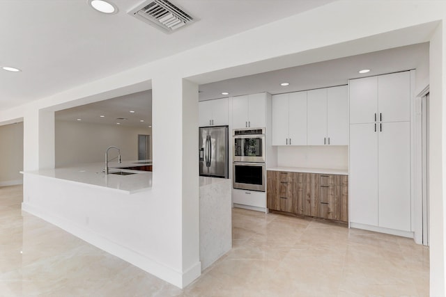 kitchen with white cabinets, stainless steel appliances, and sink