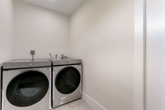 laundry room with washer and dryer and light tile patterned floors