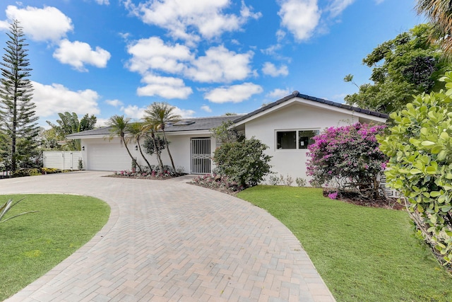 single story home with a garage and a front lawn