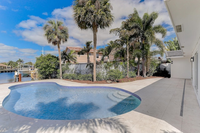 view of swimming pool with a patio and a water view