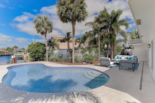 view of swimming pool with an outdoor living space, a water view, and a patio area