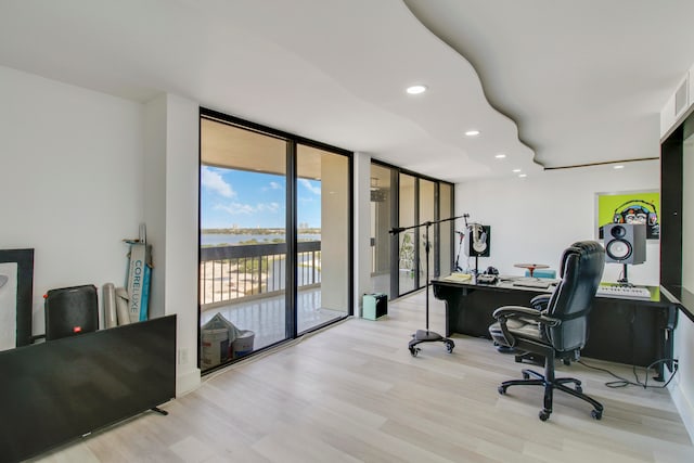 office space with expansive windows and light wood-type flooring