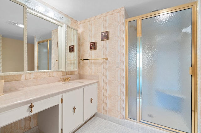 bathroom featuring tile walls, a shower with door, tile floors, and vanity with extensive cabinet space