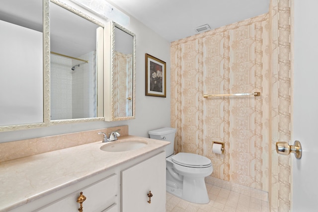 bathroom with tile floors, vanity with extensive cabinet space, and toilet