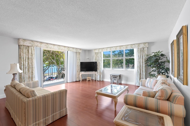 living room featuring a textured ceiling, plenty of natural light, and dark wood-type flooring