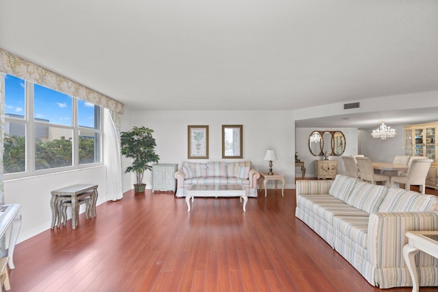 unfurnished living room with an inviting chandelier and dark hardwood / wood-style flooring