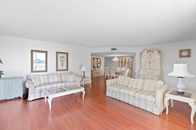 living room featuring wood-type flooring and a chandelier