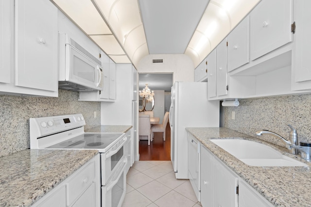 kitchen featuring white appliances, light tile flooring, white cabinetry, sink, and tasteful backsplash