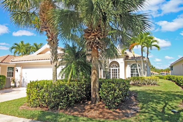 mediterranean / spanish house with a front lawn and a garage