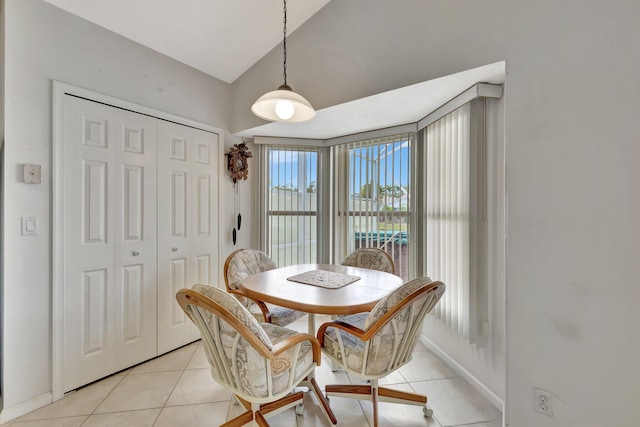 dining area featuring lofted ceiling and light tile floors