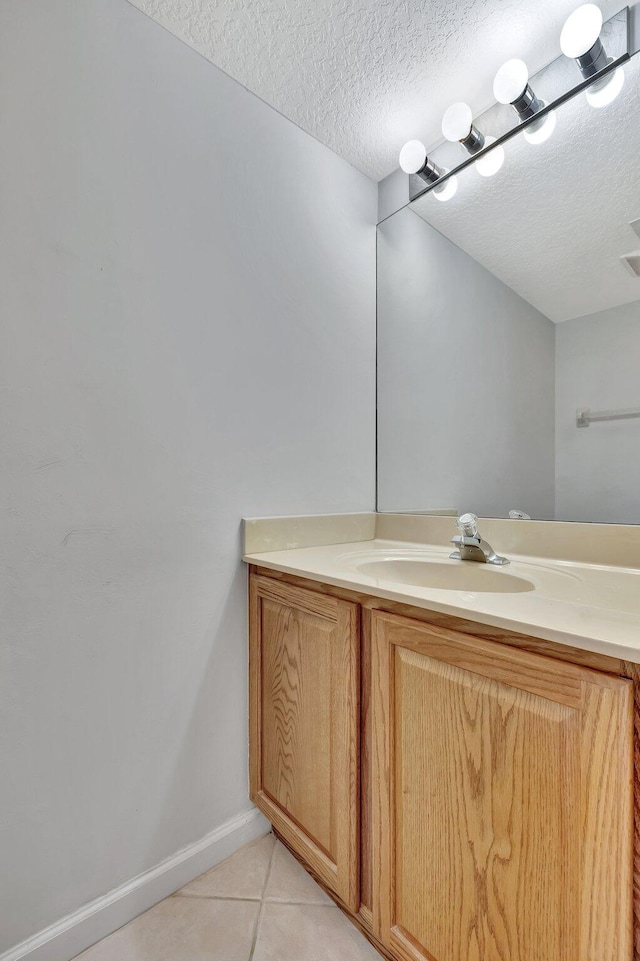 bathroom featuring tile floors, vanity, and a textured ceiling