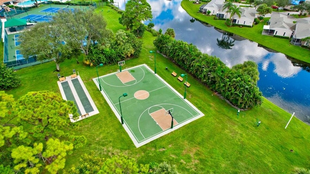 view of sport court with a yard and a water view