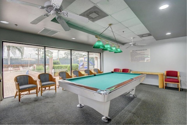 rec room with a drop ceiling, dark colored carpet, pool table, and ceiling fan