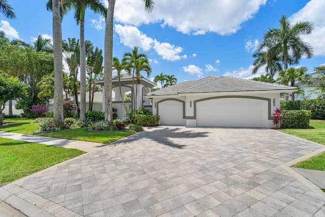 mediterranean / spanish-style house featuring a garage and a front yard