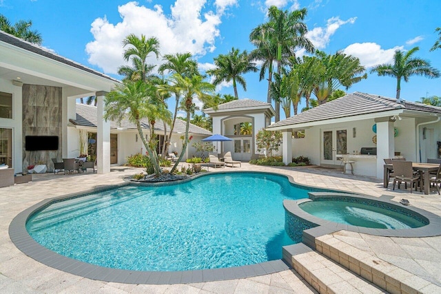 view of pool featuring a patio and an in ground hot tub