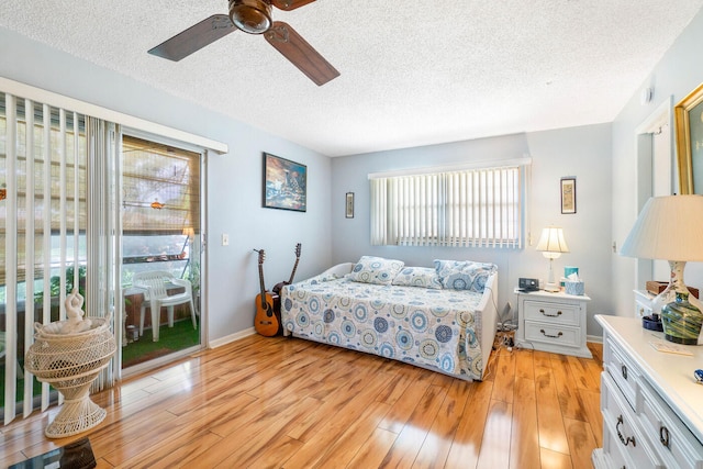 bedroom featuring ceiling fan, access to exterior, light hardwood / wood-style flooring, and a textured ceiling