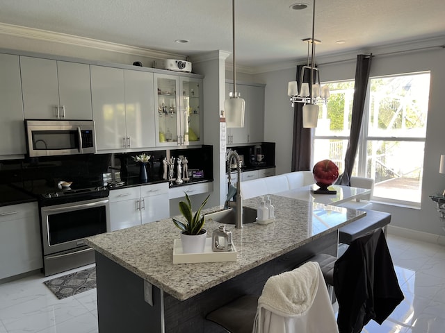 kitchen with marble finish floor, ornamental molding, stainless steel appliances, and a sink