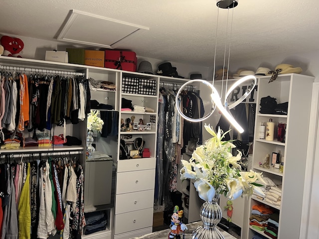 walk in closet featuring attic access