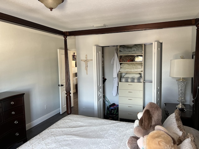 bedroom featuring wood finished floors, a closet, baseboards, and visible vents