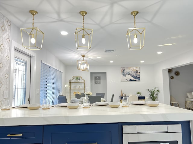 kitchen with wine cooler, blue cabinetry, and hanging light fixtures