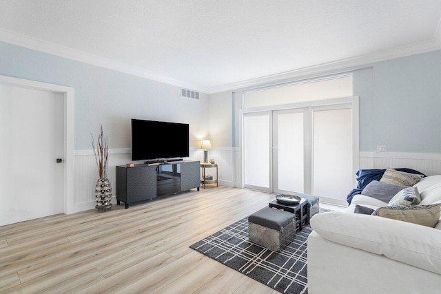 living room with wood-type flooring, a textured ceiling, and crown molding