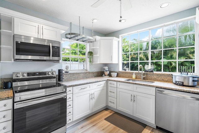 kitchen featuring white cabinets, stainless steel appliances, sink, and a healthy amount of sunlight