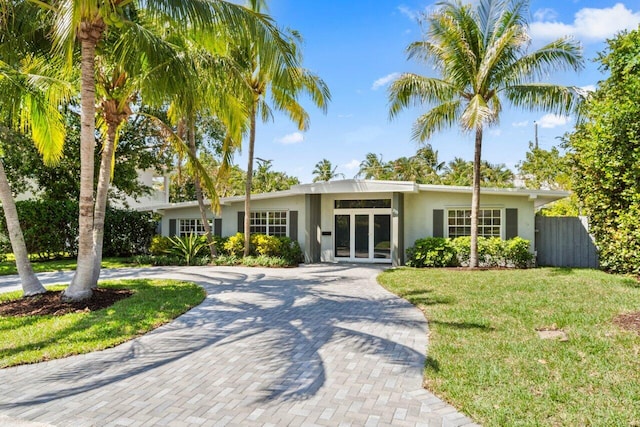 ranch-style house featuring a front lawn and french doors