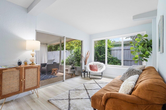 living room with light hardwood / wood-style flooring and lofted ceiling with beams