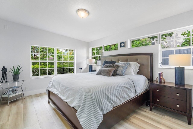 bedroom featuring lofted ceiling and light hardwood / wood-style floors