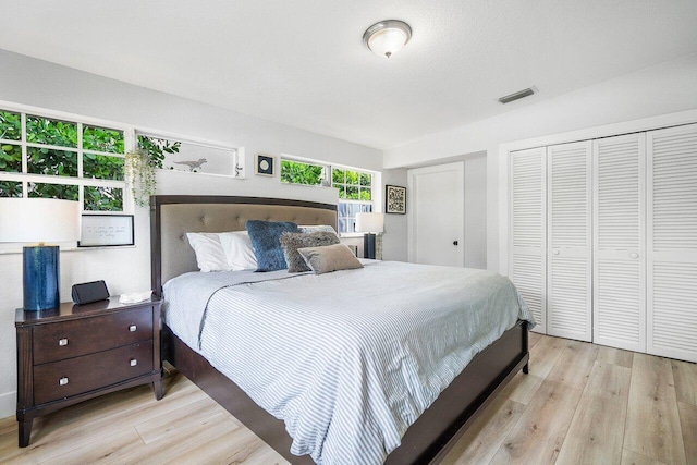 bedroom featuring light hardwood / wood-style flooring and multiple closets