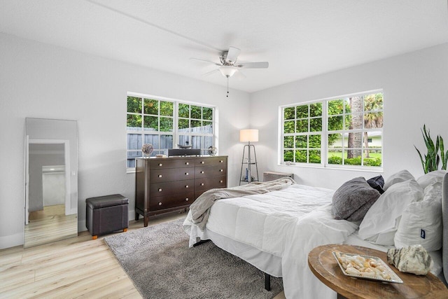 bedroom with light hardwood / wood-style flooring, multiple windows, and ceiling fan