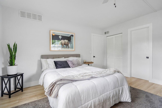 bedroom with a closet, light wood-type flooring, and ceiling fan