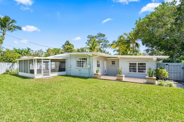 back of house with a sunroom and a lawn