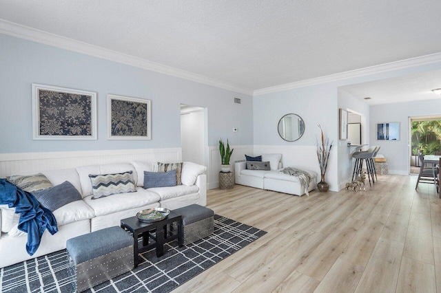 living room featuring ornamental molding, a textured ceiling, and hardwood / wood-style floors