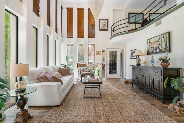 living room with dark wood-type flooring and a towering ceiling