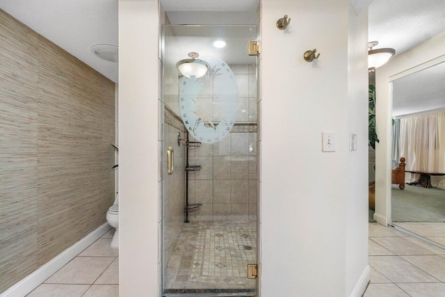 bathroom with toilet, an enclosed shower, tile floors, and a textured ceiling