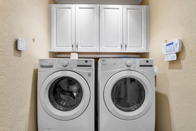 laundry area featuring washer and clothes dryer and cabinets