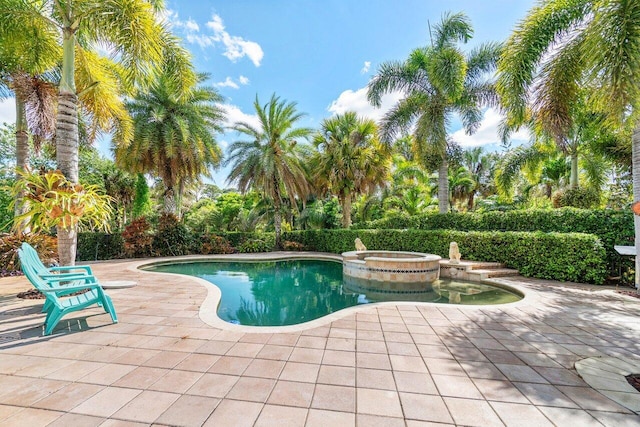 view of pool featuring a patio and an in ground hot tub