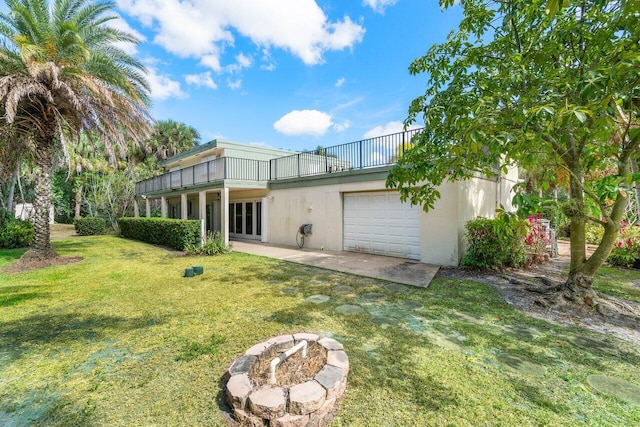 back of house featuring a yard and a garage